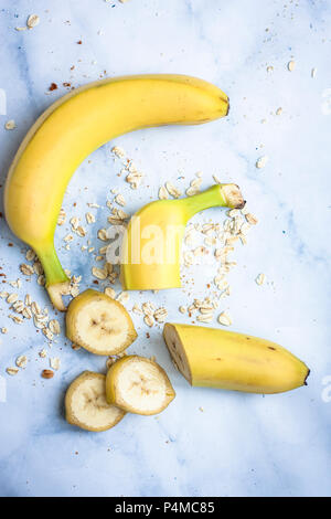 Tutta una banana e fette di banana con avena Foto Stock