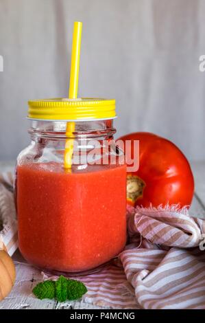 Fredda zuppa di pomodoro in una vite-top vasetto con un coperchio e una paglia Foto Stock