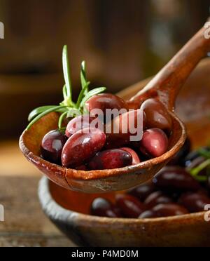 Olive Kalamata con rosmarino in un mestolo di legno Foto Stock