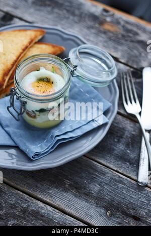 Un uovo in un bicchiere serviti con pane tostato Foto Stock