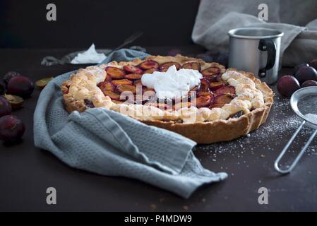 Una torta di prugne con soia vegano panna montata Foto Stock