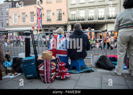 Due persone svegliati la mattina presto il Royal Wedding di S.A.R. il principe Harry e la Sig.ra Meghan Markle. Essi sedersi su passi e guardare in arrivo volontari e lavoratori del consiglio a piedi lungo le strade di Windsor a prendere posizione per l'evento. Foto Stock