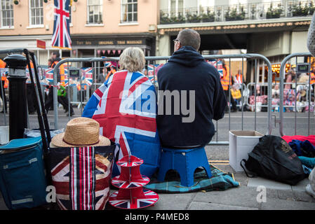 Due persone svegliati la mattina presto il Royal Wedding di S.A.R. il principe Harry e la Sig.ra Meghan Markle. Essi sedersi su passi e guardare in arrivo volontari e lavoratori del consiglio a piedi lungo le strade di Windsor a prendere posizione per l'evento. Foto Stock