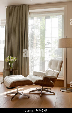 Poltrona e fiori dalla porta Foto Stock