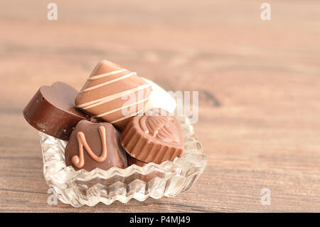 Una varietà di cioccolatini visualizzati in un elegante contenitore di vetro Foto Stock