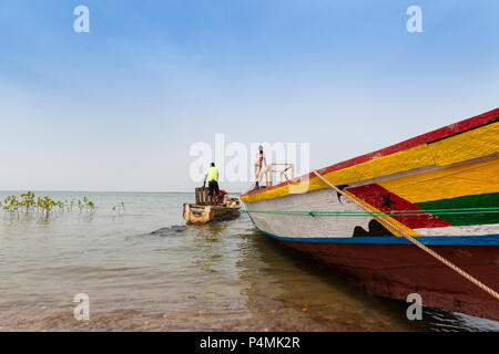 Cacheu, Repubblica di Guinea Bissau - 1 Febbraio 2018: i pescatori preparano le loro canoe nel porto della città di Cacheu in Guinea Bissau. Foto Stock