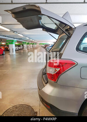 Auto Berlina, aprire baule auto nel parcheggio auto sotto shopping mall. Foto Stock
