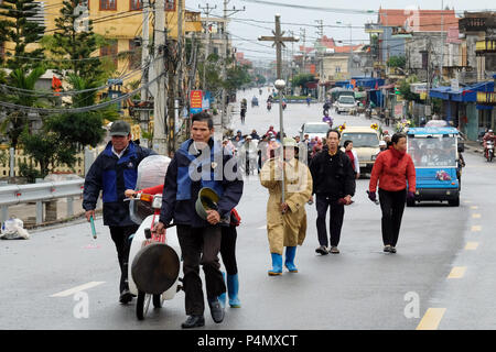 Lutto a piedi attraverso le strade di una piccola cittadina in provincia di Nam Dinh al cimitero. Vietnam - Trauergemeinde zieht durch die Straßen einer Kleinstadt in der Nam Dinh-Provinz zum Friedhof. Il Vietnam Foto Stock