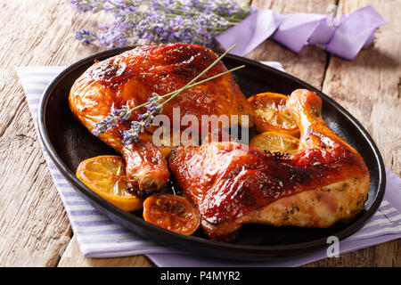 Cibo delizioso: grigliate smaltato le cosce di pollo con miele di lavanda e limone close-up su una piastra sul tavolo orizzontale. Foto Stock