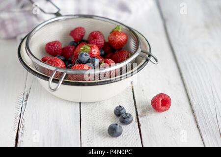 Lamponi Mirtilli e fragole in un setaccio Foto Stock