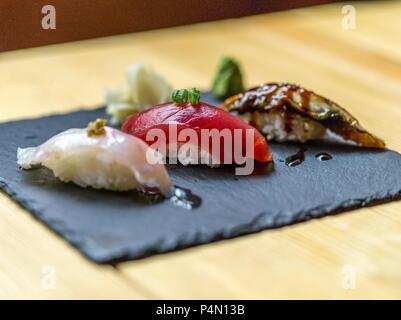 Tre tipi di sushi su un piatto di ardesia Foto Stock