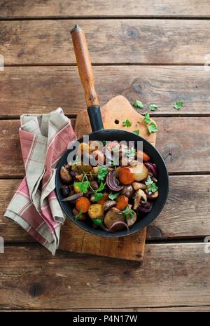 Patate, carote e funghi serviti in una padella Foto Stock