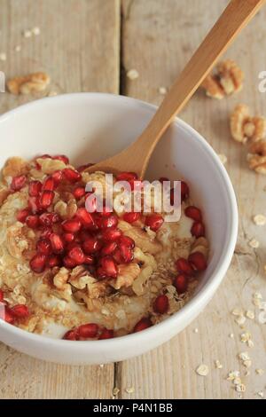 Noce di cocco vegana yogurt con avena, noci, semi di melograno e sciroppo di agave Foto Stock