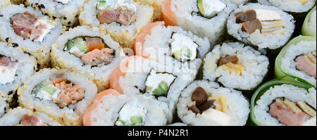 Close-up di un sacco di sushi rotoli con vari ripieni. Macro shot del classico cotto il cibo giapponese. Immagine di sfondo . Foto Stock