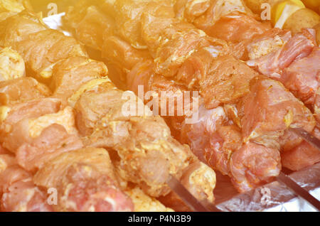 La carne cruda e le patate sono piantati su spiedini di metallo. Il processo di cottura shish kebab. Russo e ucraino cibo camp Foto Stock