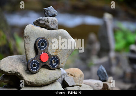 Un filatore in legno si trova su strane strutture di pietra nella foresta Foto Stock