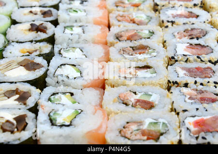Close-up di un sacco di sushi rotoli con vari ripieni. Macro shot del classico cotto il cibo giapponese. Immagine di sfondo . Foto Stock