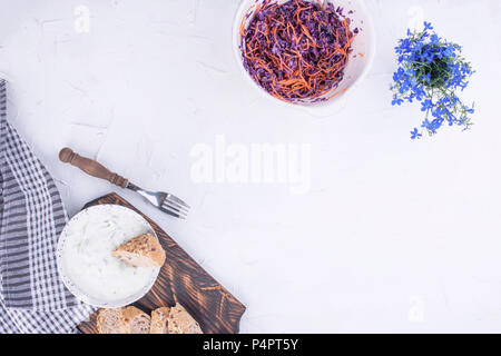 Insalata di cavolo cappuccio fresco e carote, pane fresco e lo yogurt con il cetriolo. La molla di verdure e salsa bianca. Il pranzo è vegetariano. Per una cucina sana e gustosa. Spazio di copia Foto Stock