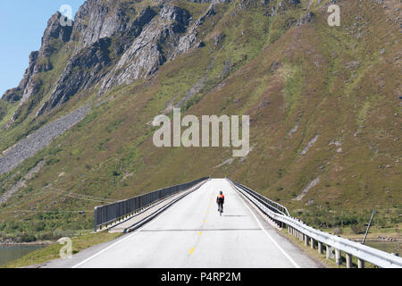 Ciclista equitazione ponte Gimsøystraumbrua, Isole Lofoten in Norvegia. Foto Stock