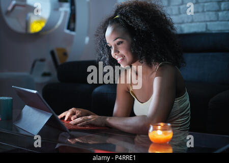 Giovane Latina donna digitando messaggio sul computer portatile di notte Foto Stock