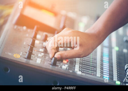 Fase professionale mixer audio closeup al sound engineer mano utilizzando il mix audio cursore lavorando durante il concerto previsto Foto Stock