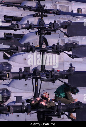 Stati Uniti Marine Corps Lance Cpl. Christopher Horvet, inferiore assegnato al Marine squadrone di attacco 542, effettua la manutenzione del rotore di un AH-1Z Super elicottero Cobra a bordo distribuita Amphibious Assault nave USS Essex (LHD 2) sett. 25, 2010, mentre sotto il titolo nel Mare delle Filippine. (DoD Foto Stock