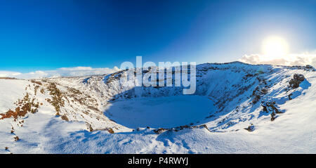 Vista panoramica del Vulcano Kerid con neve e ghiaccio nel cratere vulcanico lago in inverno sotto un cielo blu chiaro. Situato nella zona Grímsnes in così Foto Stock