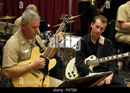 Febbraio 23, 2012 (WASHINGTON D.C.) un membro dell'Herndon High School jazz band osserva Chief Musician Gary Malvaso suonare la chitarra con il Commodores jazz ensemble durante il loro viaggio al Commodores' spazi per prove presso il Washington Navy Yard. La banda della marina di 'Musica nelle scuole", programma progettato per portare i concerti e dimostrazioni per ragazzi in etã scolare, introduce gli studenti a spettacoli di musica dal vivo da Marina professionale musicisti. Foto Stock