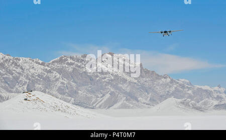 Un M-28 Trucker velivolo vola passato lo Spin Ghar montagne sull approccio per una routine di caduta di alimentazione in Shah gioia Distretto, Provincia di Zabul, Afghanistan, Feb. 24. Gocce d'aria sono un modo comune di rialimentazione coalizione di forze per le operazioni speciali in remote aree dell'Afghanistan. Foto Stock