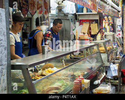 Vista di un occupato fast food street chiosco di Hong Kong di notte Foto Stock