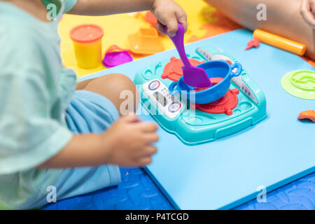 Carino bambina divertendosi colorato di creta per modellare, riproduzione di impasto a casa, prodotti per la cura del bambino di cottura degli alimenti modello, giocattoli educativi per bambini creativi per Foto Stock