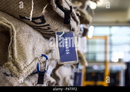 Johannesburg, Sud Africa, 7 giugno - 2018: i chicchi di caffè in sacchi di grandi dimensioni con etichette di origine torrefattori. Foto Stock