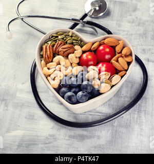 Snack sani nel cuore ciotola sagomata. Vista superiore Foto Stock