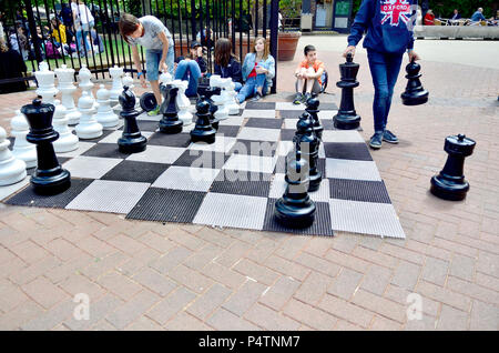 Bambini che giocano Giganti Scacchi all'aperto in Victoria Embankment Gardens, Londra, Inghilterra, Regno Unito. Foto Stock