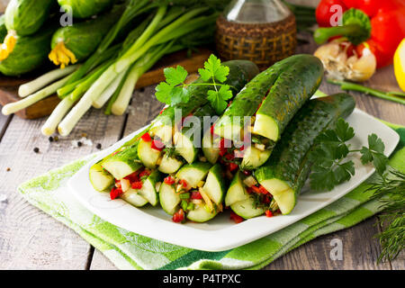 Tradizionale Coreano Kimchi alimentare (cetriolo). I cetrioli marinati con ripieno di verdure (Sweet Pepper, aglio, cipolla, verdi, il concentrato di pomodoro) sul kitch Foto Stock