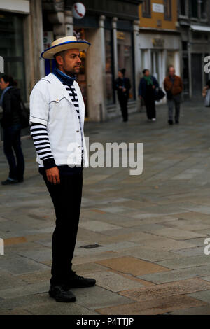 Bel giovane gondoliere veneziano in attesa di mattina presto i clienti a San Bartolomeo Square, Rialto, Venezia, Italia Foto Stock