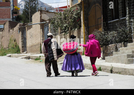 Famiglia boliviana camminare per le strade di Copacabana Foto Stock