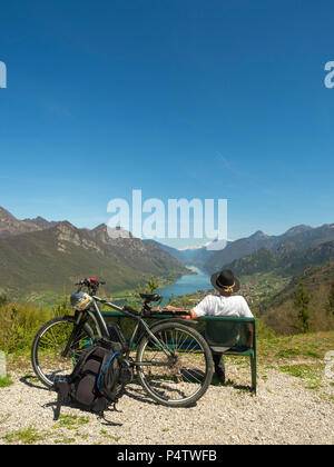 L'Italia, Regione Lombardia, Senior escursionista che guarda sul lago d'Idro, Adamello Alpi, Parco Naturale Adamello Brenta Foto Stock