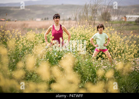 Madre e figlia fare yoga nella natura Foto Stock
