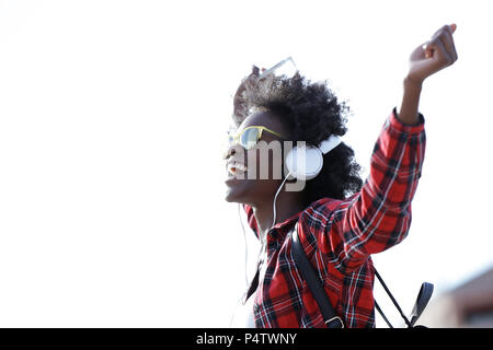 Felice giovane donna ascolto di musica con le cuffie e il telefono cellulare Foto Stock