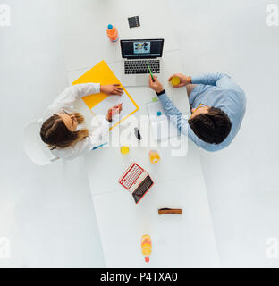 Due persone di affari al tavolo riunione in ufficio, vista dall'alto Foto Stock