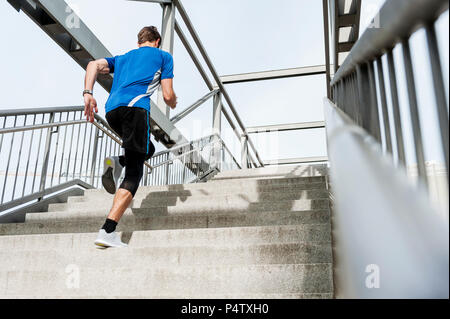 Uomo che corre su per le scale Foto Stock