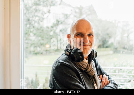 Ritratto di un sorridente senior uomo con le cuffie Foto Stock