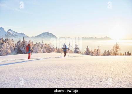 Austria, Tirolo, escursionisti con racchette da neve a sunrise Foto Stock