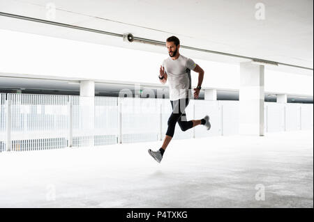 Uomo che corre in garage Foto Stock