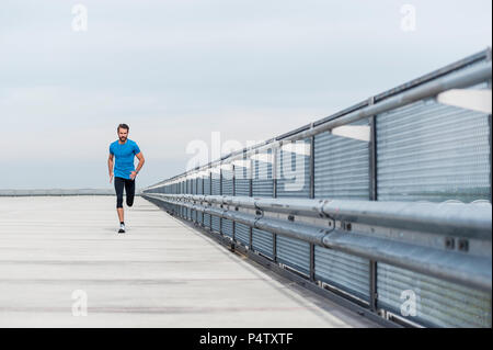 Uomo che corre su un livello di parcheggio Foto Stock