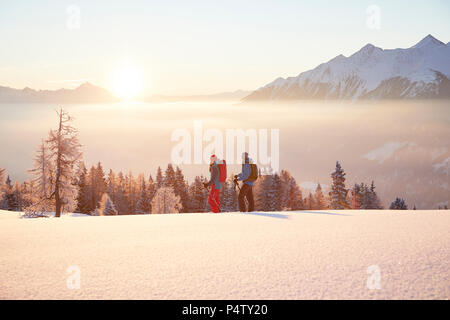 Austria, Tirolo, escursionisti con racchette da neve a sunrise Foto Stock