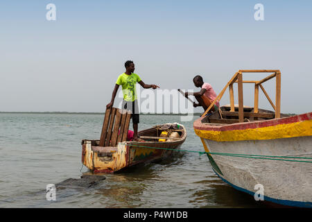 Cacheu, Repubblica di Guinea Bissau - 1 Febbraio 2018: i pescatori preparano le loro canoe nel porto della città di Cacheu in Guinea Bissau. Foto Stock