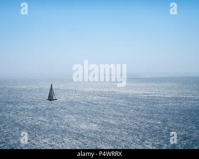 Barca a vela solitaria vele lungo l'Oceano Pacifico su una grande giornata di sole Foto Stock