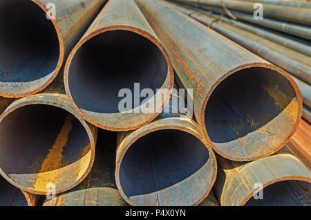 Il fabbricato mediante saldatura tonda in acciaio arrugginito tubi impilati all'aperto di magazzino Foto Stock